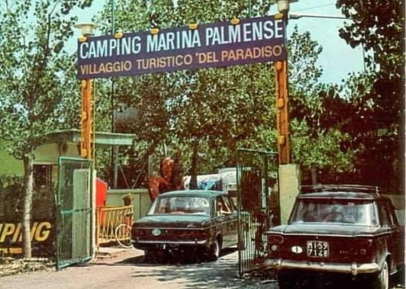 Ingresso del Camping Marina Palmense con auto d'epoca parcheggiate.